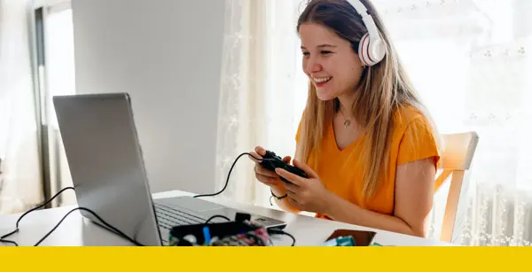 Online High School eSports League image 9 (name girls playing computer games on laptop with headphones on)